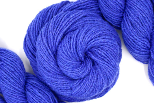 A skein of Violet, Dk weight Yarn recycled by hand from unwanted sweaters swirled attractively in the center of the frame.