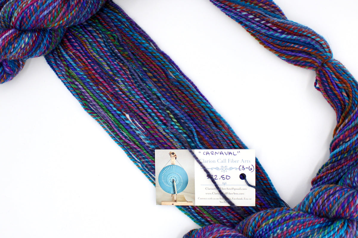 A one of a kind, hand dyed Variegated skein of multicolored Rainbow self-striping wool Yarn draped diagonally across the frame, so you can really see the color play.