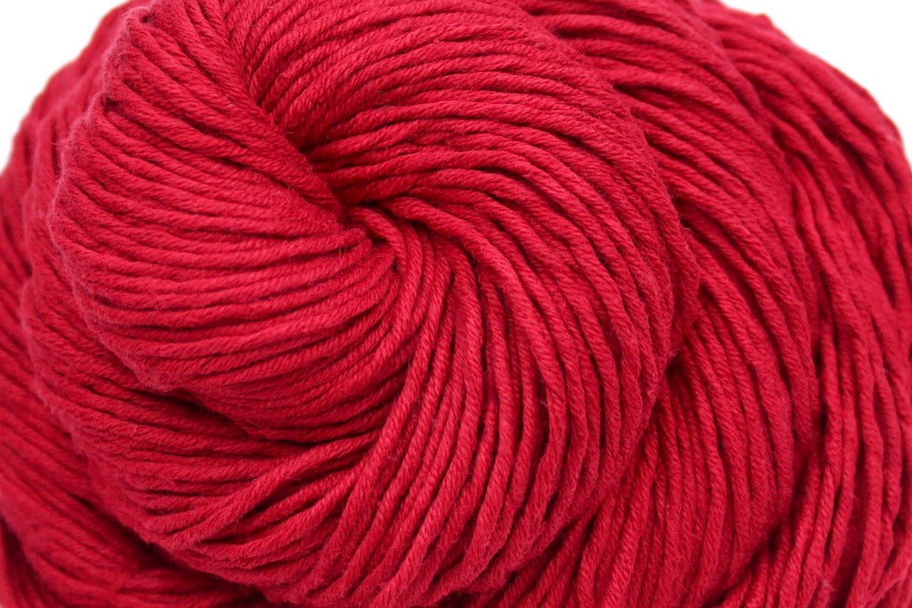 A close up shot of a skein of Ruby Red, Dk weight Yarn recycled by hand from unwanted sweaters beautifully coiled in the center of the frame.