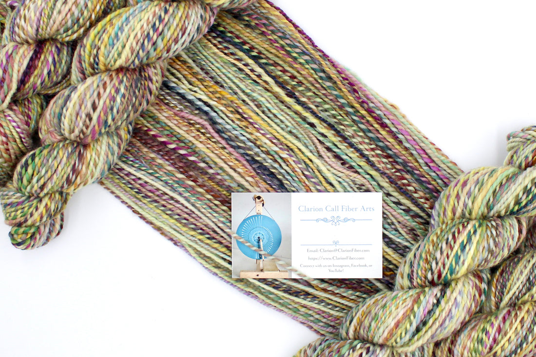 A one of a kind, Worsted weight, hand dyed variegated skein of multicolored Green, Maroon, Pink, Yellow and Chartreuse, self-striping superwash wool Yarn draped diagonally across the frame, so you can really see the color play.