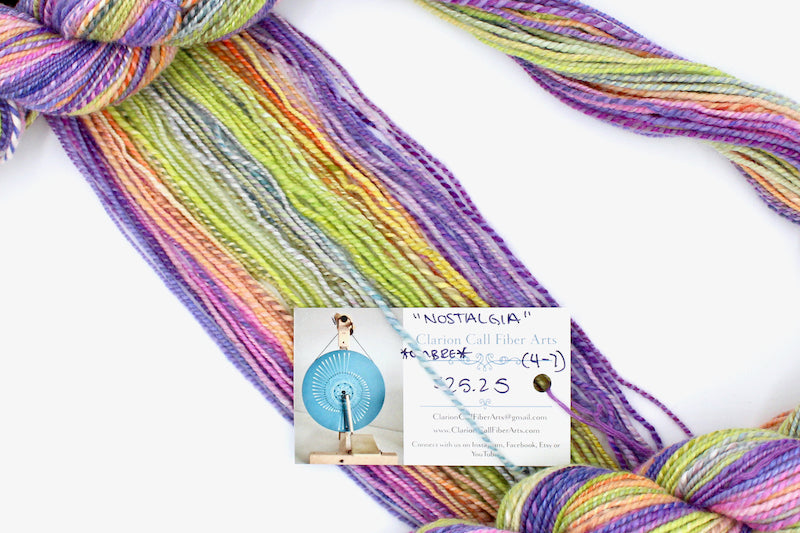 A one of a kind, hand dyed gradient skein of multicolored Purple, Neon Pink, Orange, Yellow Neon Green, and Light Blue self-striping wool Yarn draped diagonally across the frame, so you can really see the color play.