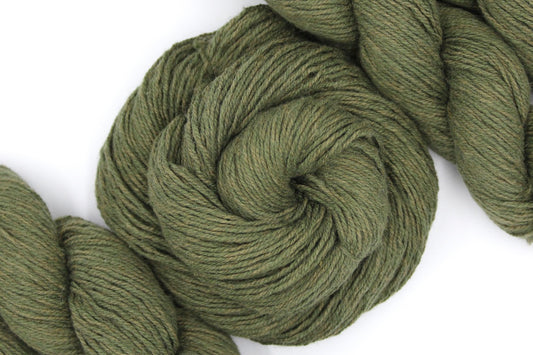 A skein of Heathered Sage, Olive Green, Cotton/ Nylon/ Wool, Sport weight Yarn recycled by hand from unwanted sweaters swirled attractively in the center of the frame.