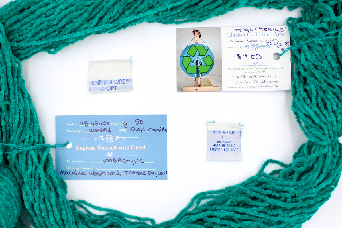 A skein of Vegan, Bright Teal, 100% Acrylic, Worsted Weight Chenille yarn encircling the sweater labels it was recycled from, as well as the hand written yarn tags detailing the specs of this recycled yarn to help you make your next project!