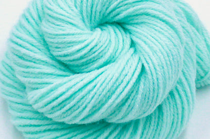 A close up shot of a skein of Vegan, Light Pastel Aquamarine 100% Acrylic, Worsted weight Yarn recycled by hand from unwanted sweaters beautifully coiled in the center of the frame. 
