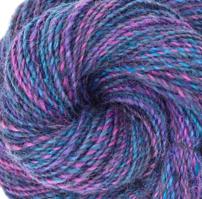 A close up view of a one of a kind, hand dyed Variegated skein of multicolored Hot Pink, Blue, and Purple self-striping wool Yarn. 