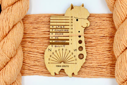 A skein of Vegan, Light Orange, 100% Cotton, DK Weight Yarn recycled by hand from unwanted sweaters draped over the center of the frame with one strand on top of a Llama shaped Yarn weight tool, to better illustrate the thickness of the yarn. 