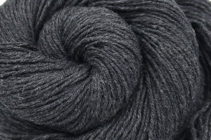 A close up shot of a skein of Dark Grey, Fingering weight Yarn recycled by hand from unwanted sweaters beautifully coiled in the center of the frame. 