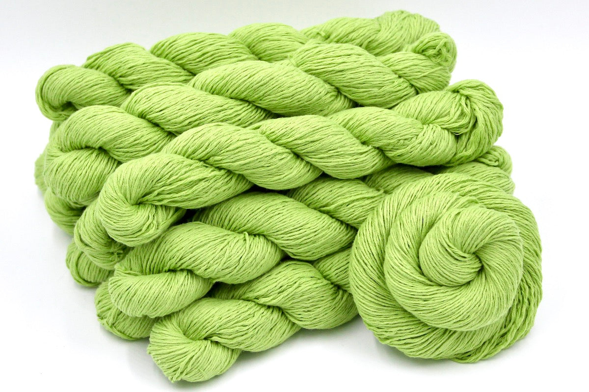 Several skeins of Lime Green, Fingering weight recycled by hand from unwanted sweaters stacked on top of each other attractively. 