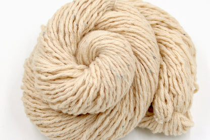 A close up shot of a skein of Beige or Cream, 90% Upcycled Acrylic, 10% Wool, Heavy Worsted (or Aran) Weight Yarn recycled by hand from unwanted sweaters beautifully coiled in the center of the frame. 