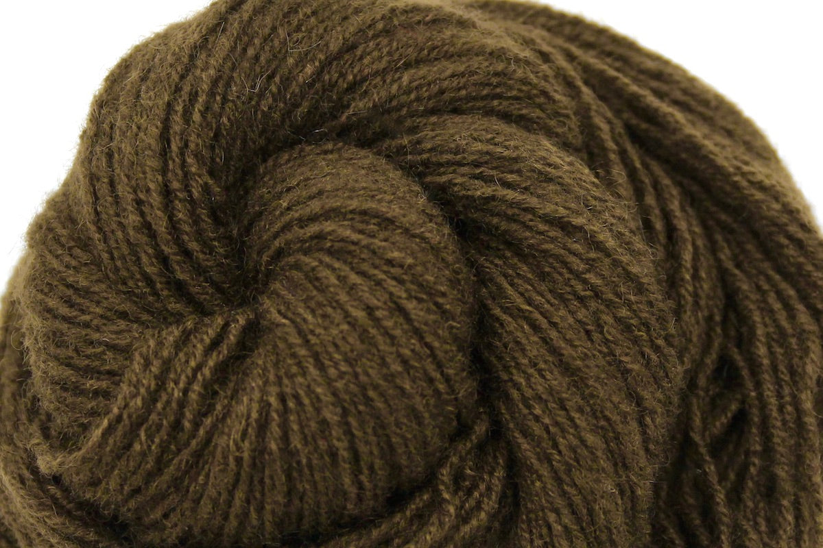 A close up shot of a skein of Dark Olive Cashmere, Fingering weight Yarn recycled by hand from unwanted sweaters beautifully coiled in the center of the frame. 