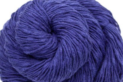 A close up shot of a skein of Deep Violet, Cotton Boucle, Dk weight Yarn recycled by hand from unwanted sweaters beautifully coiled in the center of the frame. 