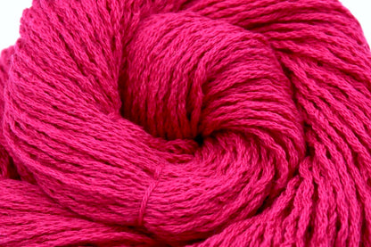 A close up shot of a skein of Hot Pink Fuchsia, Cotton/ Nylon/ Wool/ Polyester, Worsted weight Yarn recycled by hand from unwanted sweaters beautifully coiled in the center of the frame. 