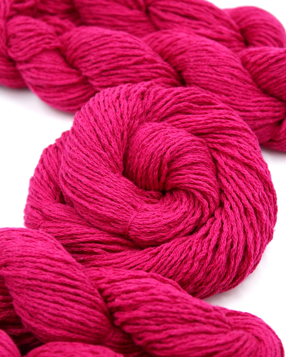 Several skeins of Hot Pink Fuchsia, Cotton/ Nylon/ Wool/ Polyester, Worsted weight recycled by hand from unwanted sweaters stacked on top of each other attractively. 