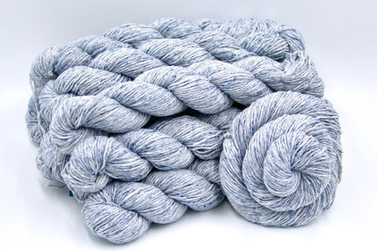 Several skeins of Pale Blue Speckled, Cotton/ Acrylic, Dk weight recycled by hand from unwanted sweaters stacked on top of each other attractively. 