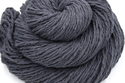 A close up shot of a skein of Vegan, Dark Grey, 60% Cotton, 40% Acrylic, Worsted Weight Yarn recycled by hand from unwanted sweaters beautifully coiled in the center of the frame. 