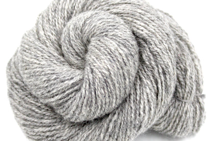 A close up shot of a skein of Light heathered grey, 90% Lambs wool and 10% cashmere, Dk Weight Yarn recycled by hand from unwanted sweaters beautifully coiled in the center of the frame. 