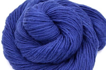 A close up shot of a skein of Vegan, Purplish Blue, Cotton, Nylon, Rayon, Dk Weight Yarn recycled by hand from unwanted sweaters beautifully coiled in the center of the frame. 