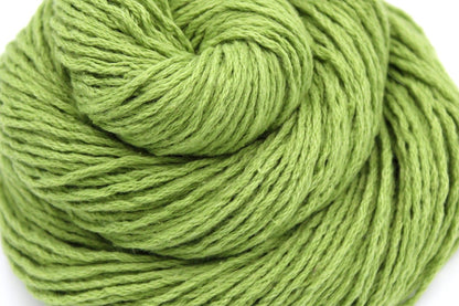 A close up shot of a skein of Vegan, Lime Green/ Chartreuse, Cotton/ Acrylic, Dk weight Yarn recycled by hand from unwanted sweaters beautifully coiled in the center of the frame. 