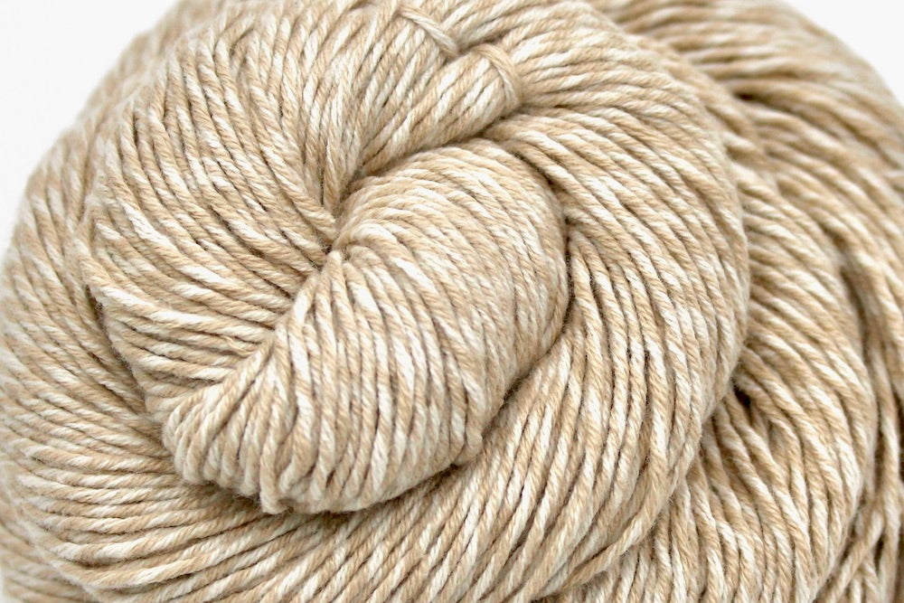 A close up shot of a skein of Vegan, Light Tan/ Taupe/ Khaki, 100% Cotton, Sport weight Yarn recycled by hand from unwanted sweaters beautifully coiled in the center of the frame. 