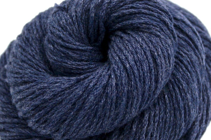 A close up shot of a skein of Vegan, Slate Navy Blue, Cotton/ Acrylic, Dk weight Yarn recycled by hand from unwanted sweaters beautifully coiled in the center of the frame. 