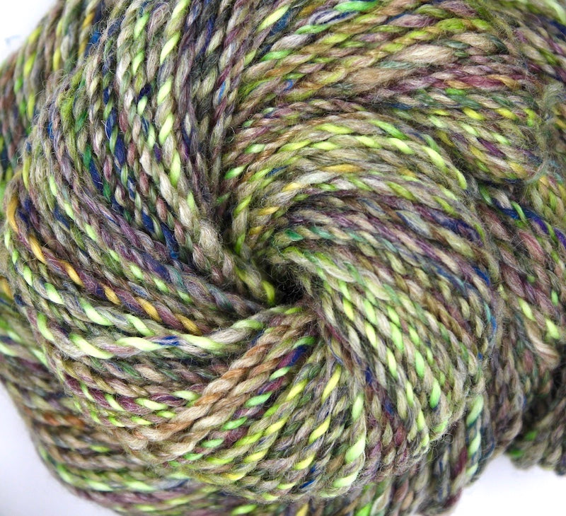 A close up view of a one of a kind, hand dyed Variegated skein of multicolored Lime Green, Yellow, Maroon and Navy Blue self-striping wool Yarn. 
