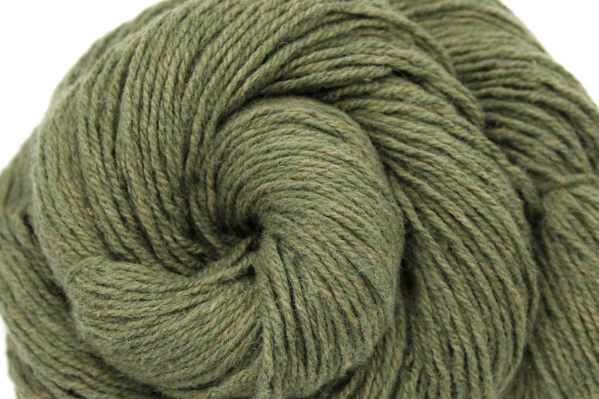 A close up shot of a skein of Heathered Sage, Olive Green, Cotton/ Nylon/ Wool, Sport weight Yarn recycled by hand from unwanted sweaters beautifully coiled in the center of the frame. 