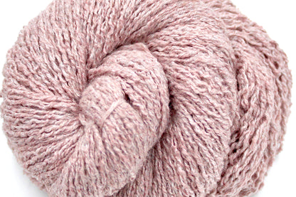 A close up shot of a skein of Vegan, Dusky Pink, Cotton, Polyester, Acrylic, Nylon, Sport Weight Yarn recycled by hand from unwanted sweaters beautifully coiled in the center of the frame. 