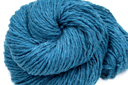 A close up shot of a skein of Vegan, Dark Greenish Teal, Cotten blend, Worsted Weight Yarn recycled by hand from unwanted sweaters beautifully coiled in the center of the frame. 