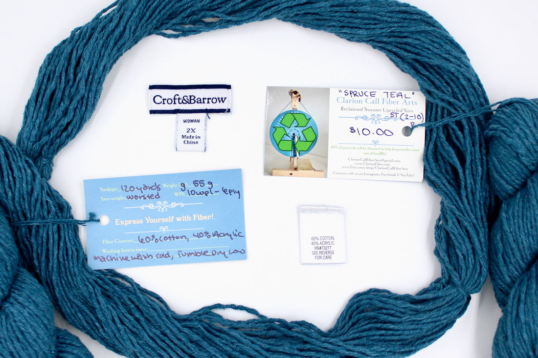 A skein of Vegan, Dark Greenish Teal, Cotten blend, Worsted Weight yarn encircling the sweater labels it was recycled from, as well as the hand written yarn tags detailing the specs of this recycled yarn to help you make your next project! 