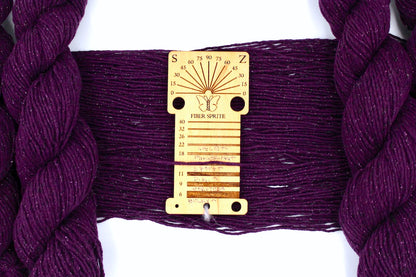 A skein of Vegan, Deep Plum Purple, Cotton/ Polyester/ Sparkle Fiber, Sport Weight Yarn recycled by hand from unwanted sweaters draped over a Llama shaped Yarn weight tool. 