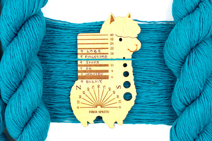 A skein of Vegan, Teal blue, 100% Cotton, Sport Weight Yarn recycled by hand from unwanted sweaters draped over the center of the frame with one strand on top of a Llama shaped Yarn weight tool, to better illustrate the thickness of the yarn. 