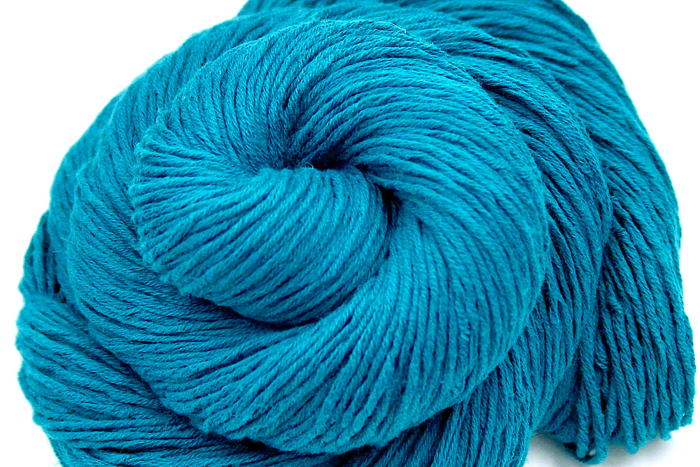 A close up shot of a skein of Vegan, Teal blue, 100% Cotton, Sport Weight Yarn recycled by hand from unwanted sweaters beautifully coiled in the center of the frame. 