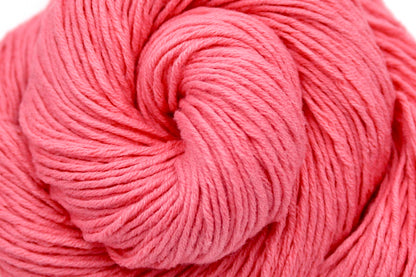 A close up shot of a skein of Vegan, Neon Rose Pink/ Fuchsia, 100% Cotton, Sport weight Yarn recycled by hand from unwanted sweaters beautifully coiled in the center of the frame. 