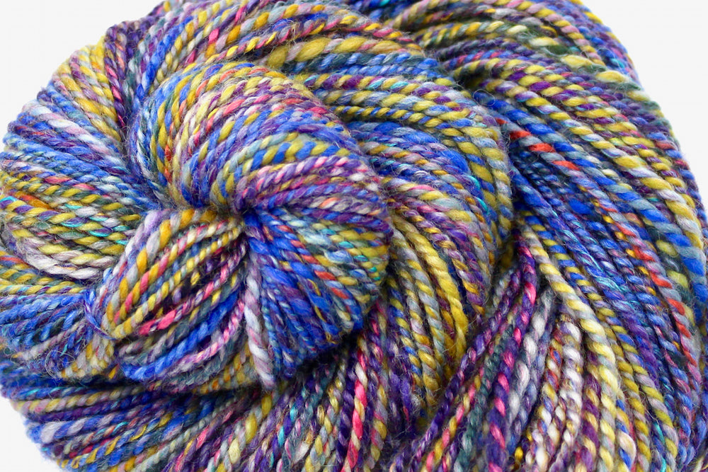 A close up view of a one of a kind, Worsted Weight, hand dyed variegated skein of Rainbow multicolored self-striping Hand spun Yarn, made with Hand Dyed Wool and Bamboo. 