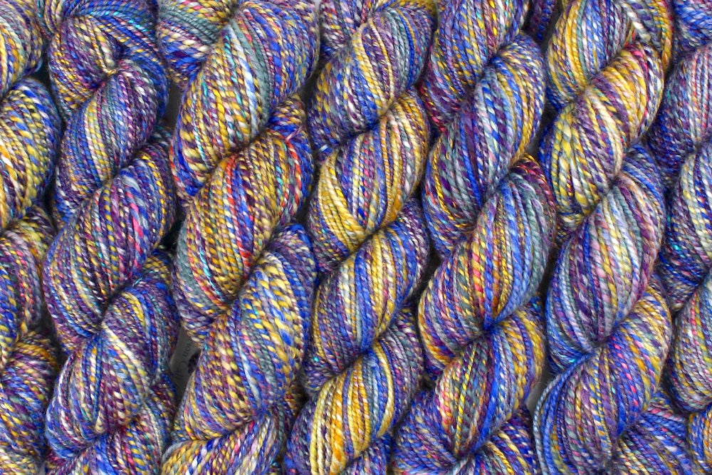 Six one of a kind, Worsted Weight, hand dyed variegated skein of Rainbow multicolored self-striping Hand spun Yarn, made with Hand Dyed Wool and Bamboo, lined up side by side. 