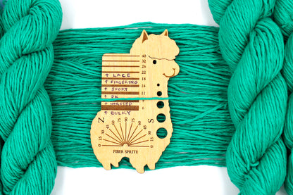 A skein of Vegan, Bright Blue Green, 100% Cotton, Worsted Weight Yarn recycled by hand from unwanted sweaters draped over the center of the frame with one strand on top of a Llama shaped Yarn weight tool, to better illustrate the thickness of the yarn. 