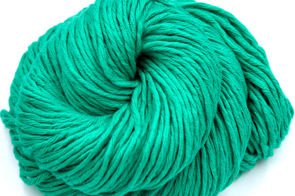 A close up shot of a skein of Vegan, Bright Blue Green, 100% Cotton, Worsted Weight Yarn recycled by hand from unwanted sweaters beautifully coiled in the center of the frame. 